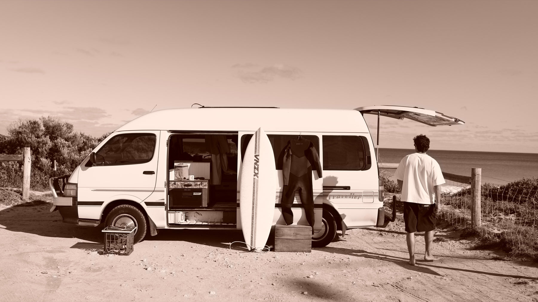 the van parked by the dunes, walking off toward the water